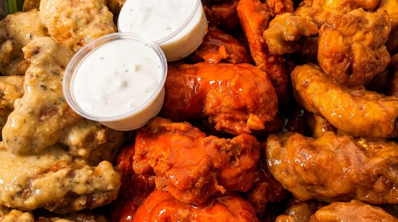 Three varieties of chicken wings: garlic parmesan, buffalo, and honey barbecue, with ranch dipping sauce.